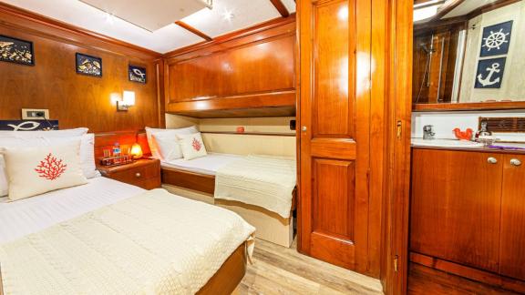 Cosy cabin with double bed, single bed and wood panelling.